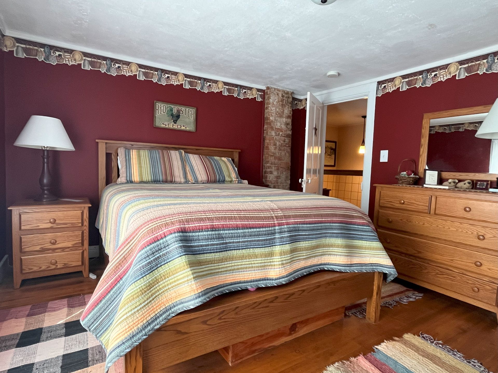 A rustic bedroom with blue walls, a quilt with different shades of blue, and a wooden bed frame.